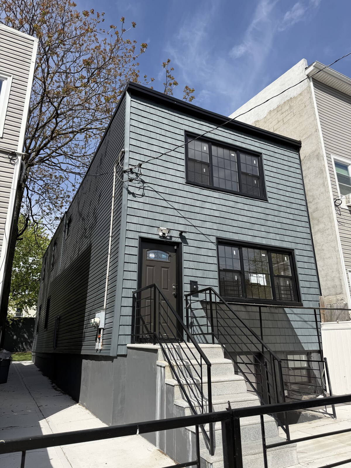Finished NYC home with new dark shingle siding by IronSky