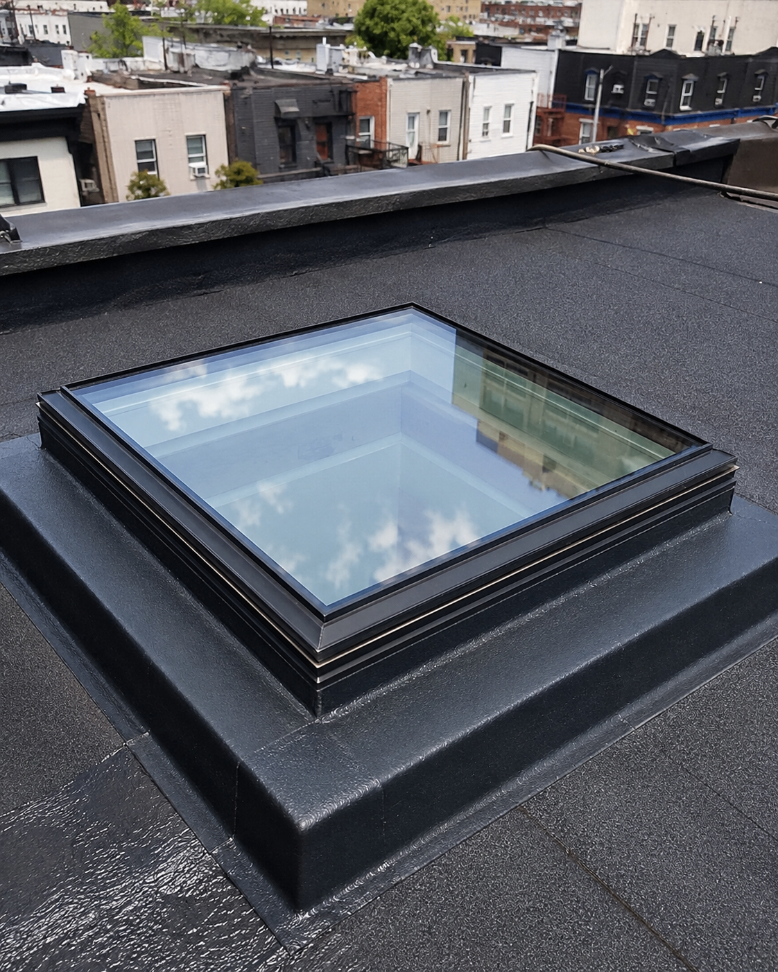 Watertight membrane and flashing around a finished skylight curb